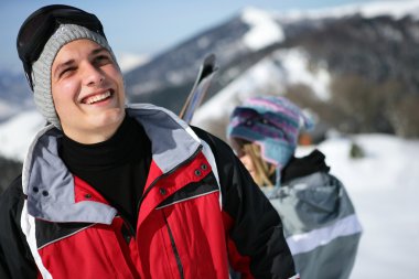 Young man in a red ski jacket clipart