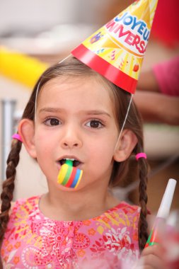 Young girl at a child's birthday party clipart