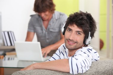 Portrait of a young man listening to music clipart