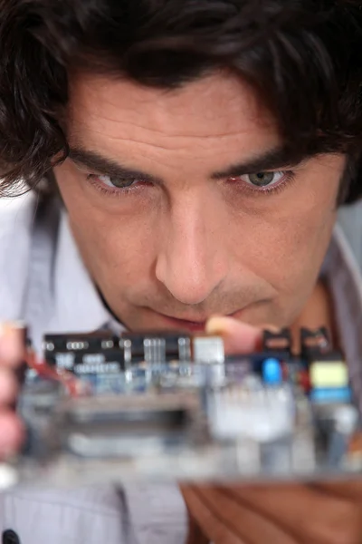 Man looking at a motherboard — Stock Photo, Image