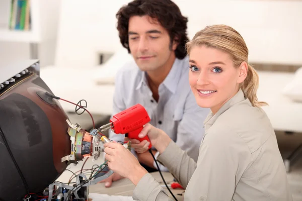 Woman soldering television — Stock Photo, Image