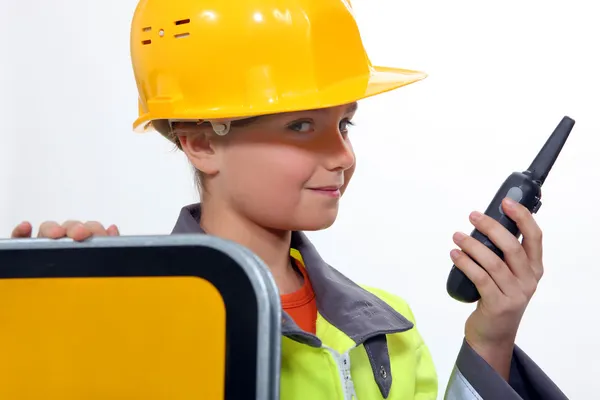 Criança vestida de homem de estrada está segurando um walkie talkie — Fotografia de Stock