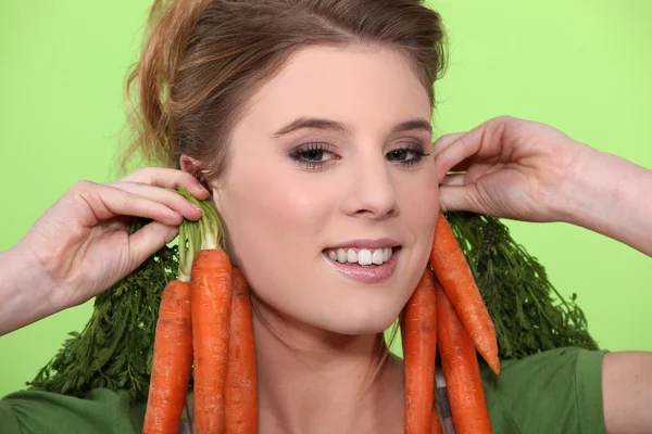 Woman wearing carrots as earrings — Stock Photo, Image