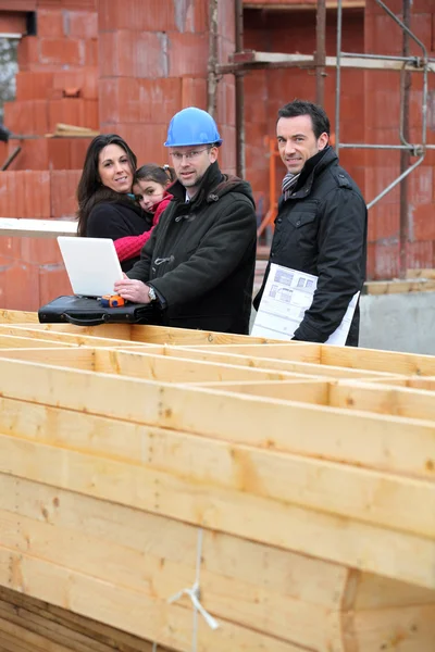 Архитектор с молодой семьей на строительной площадке — стоковое фото