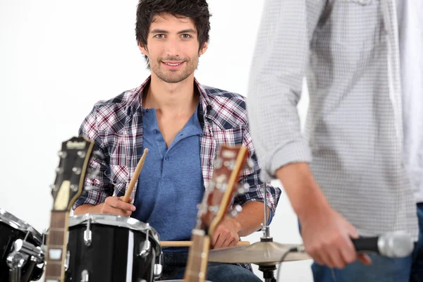 Молодой человек играет на барабанах — стоковое фото