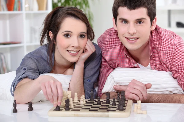 Jeune homme et jeune femme jouant aux échecs — Photo