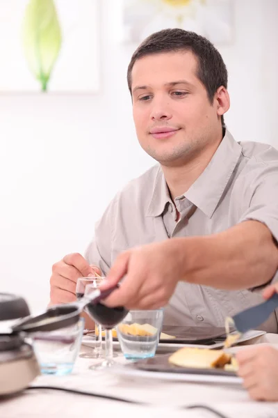 Homem comendo raclette — Fotografia de Stock