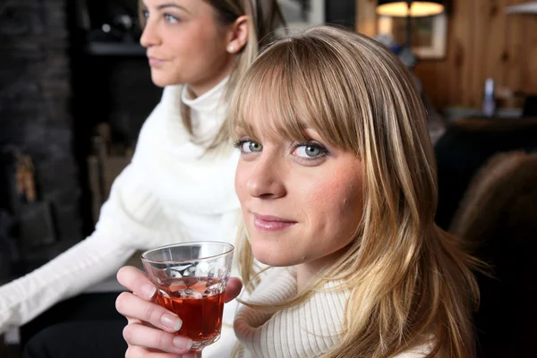 Twee vrouwelijke vrienden ontspannen thuis met glas wijn — Stockfoto