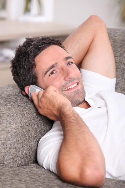 Närbild av en man som pratar i telefon i hemmet — Stockfoto