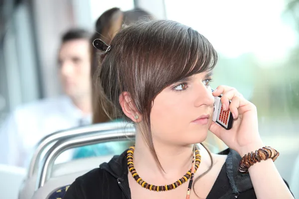 Junge Frau benutzt Handy in Straßenbahn — Stockfoto