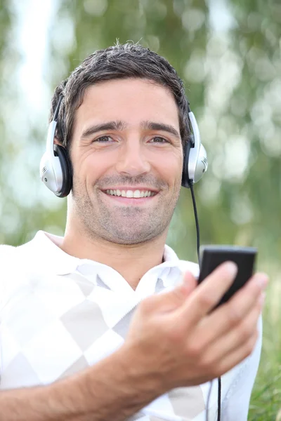 Człowiek słuchanie muzyki w parku — Zdjęcie stockowe