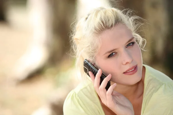 Blond woman making call outdoors — Stock Photo, Image