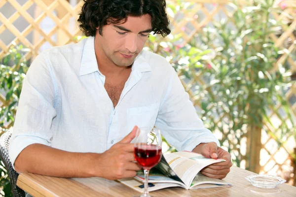 在餐厅的露台上喝红酒的男人 — 图库照片