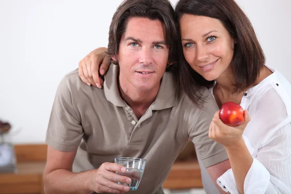 Casal com uma maçã e um copo de água — Fotografia de Stock