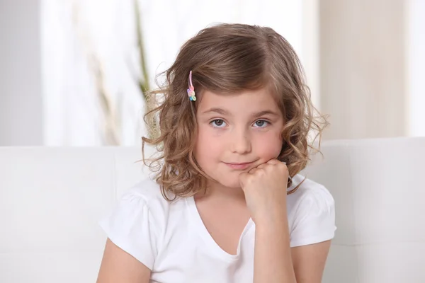 Young girl sitting on a sofa — Stock Photo, Image