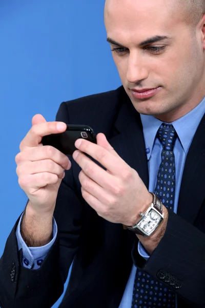 Бизнесмен смотрит на свой смартфон — стоковое фото