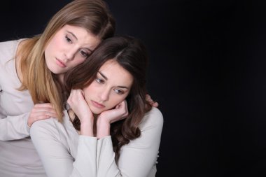 Young woman trying to comfort her friend clipart