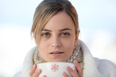 Woman drinking from large mug of coffee clipart