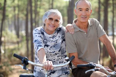 Elderly couple on bike ride clipart