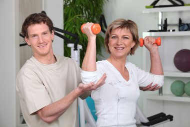 Woman being helped by her personal trainer clipart