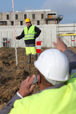 Two men measuring construction site clipart