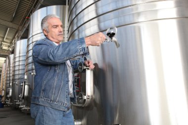 Wine producer stood by tanks clipart