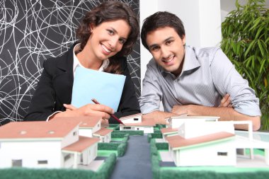 Agent and client looking at a new-build property model clipart