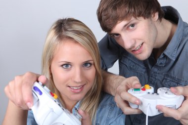 Teenagers using handsets for a games console clipart