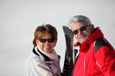 Senior couple on a ski vacation clipart