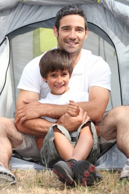 Father and son in front of their tent clipart