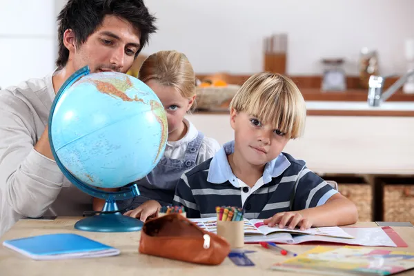 Brother and sister doing geography homework — Stock Photo, Image