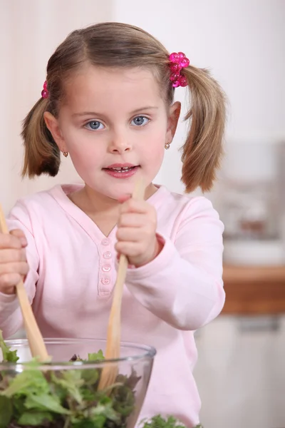 Chica joven lanzando una ensalada — Foto de Stock