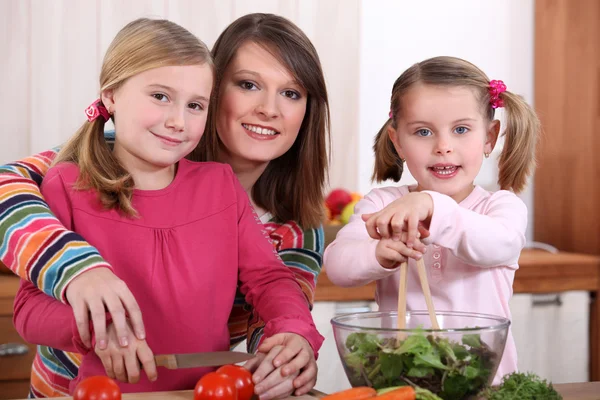 Mutter und ihre beiden Mädchen machen einen Salat — Stockfoto