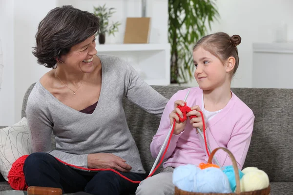 Kobieta uczy jej wnuczka jak robić na drutach — Zdjęcie stockowe