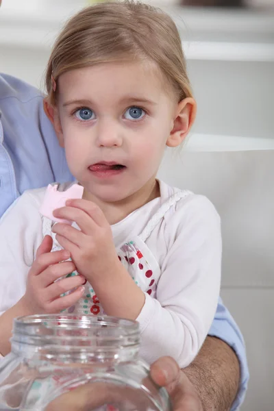 Маленька дівчинка в руках батька їсть зефір . — стокове фото