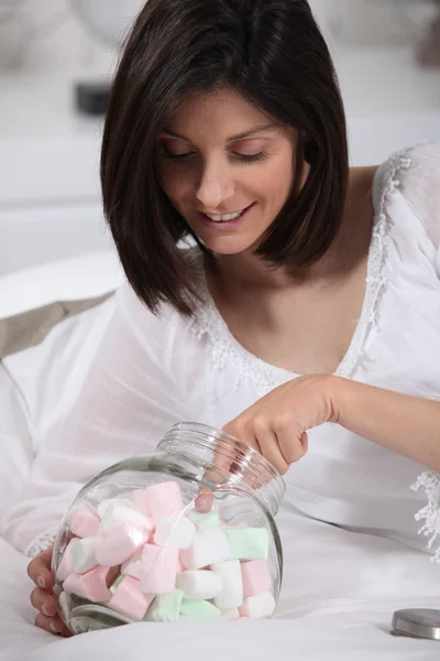 Wanita dengan tangannya dalam botol marshmallow — Stok Foto