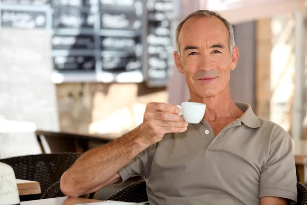 Idoso tomando um café expresso em um terraço — Fotografia de Stock