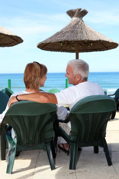 海辺に座っての中年夫婦 — ストック写真