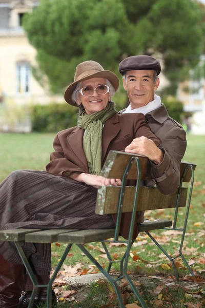 Casal mais velho sentado em um banco — Fotografia de Stock