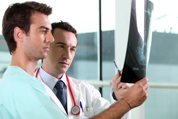 Dois colegas médicos a olhar para a imagem do raio-X — Fotografia de Stock
