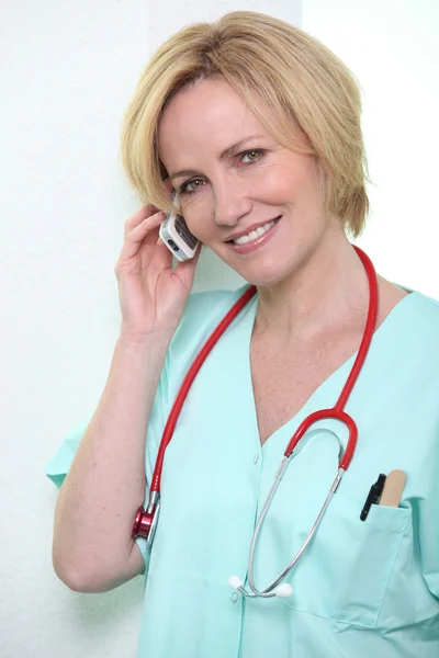 Медицинский работник разговаривает по мобильному телефону — стоковое фото