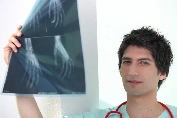 Unga manliga sjukvårdare undersöka xrays av händer — Stockfoto