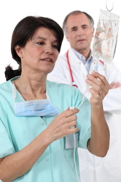 Médico e enfermeiro com gotejamento IV — Fotografia de Stock
