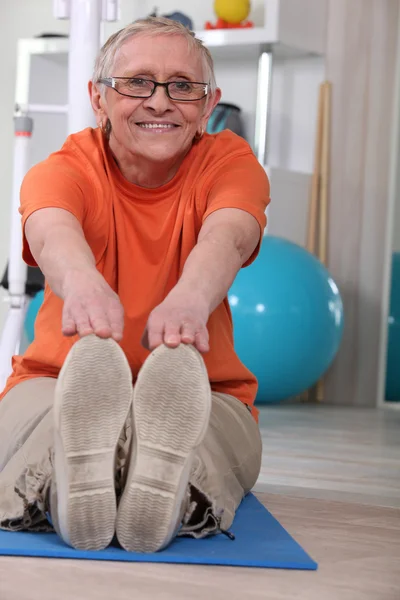 Seniorin macht Bodenübungen — Stockfoto