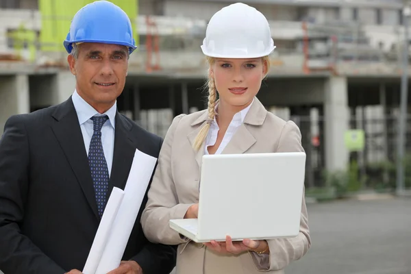 Biznesmen i kobieta pomocnik na budowie — Zdjęcie stockowe