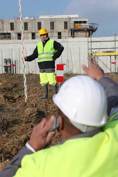 Two men measuring construction site — Stock Photo, Image