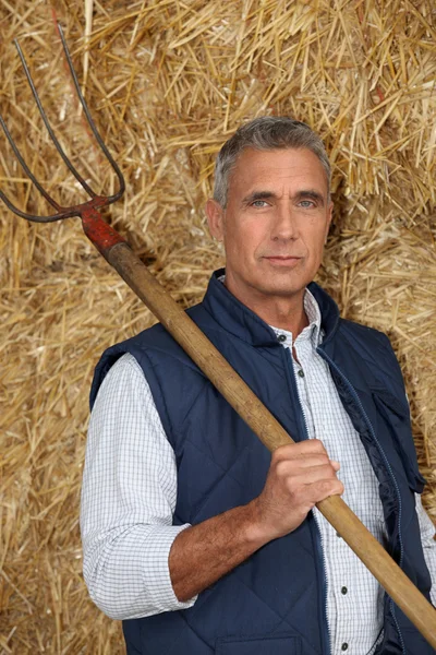 Farmer holding a pitchfork — Stock Photo, Image