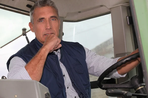 Um agricultor em uma cabine trator está dirigindo — Fotografia de Stock