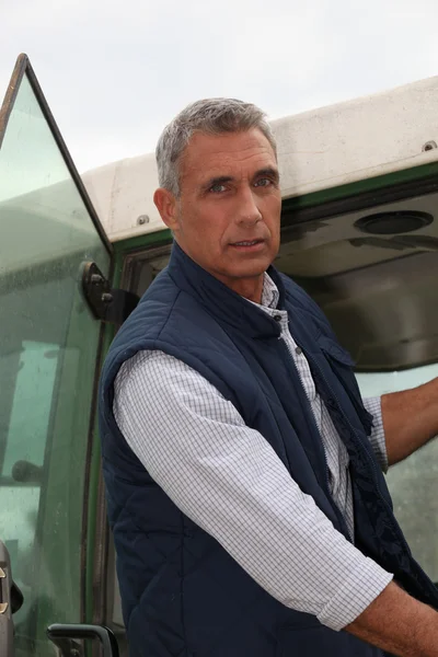Farmer getting into tractor — Stok fotoğraf