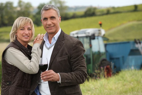 Bauer mit Glas Wein stand vor Traktor — Stockfoto
